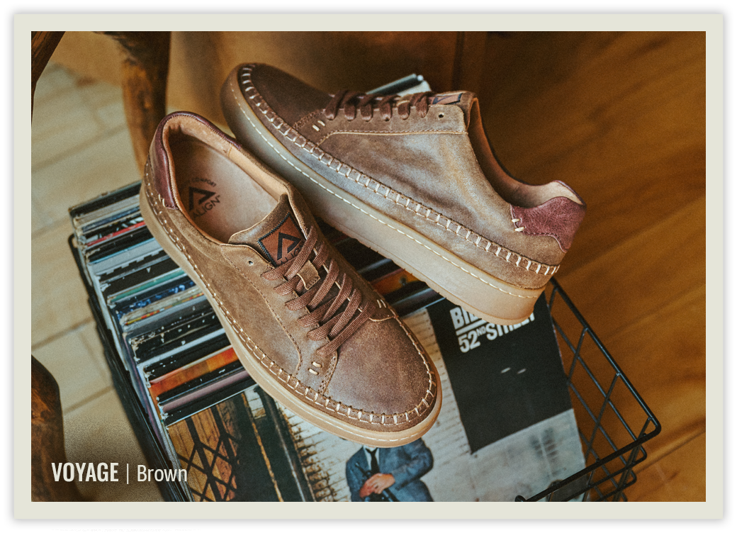 The Voyage sneaker in Brown sitting on a bin of vinyl records.