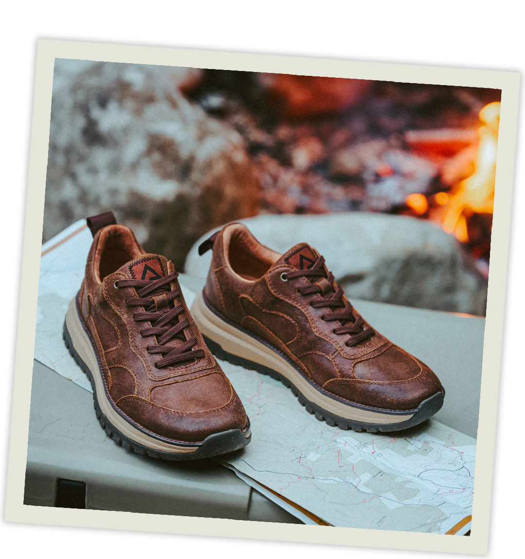 The Breck Sneakers in Brown sitting on top of a cooler in front of a camp fire.
