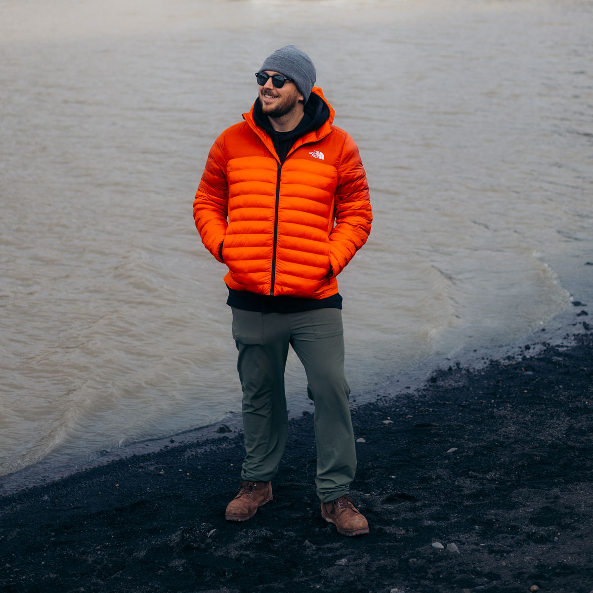 A man wearing the Ryder in brown leather while standing in front of a body of water.