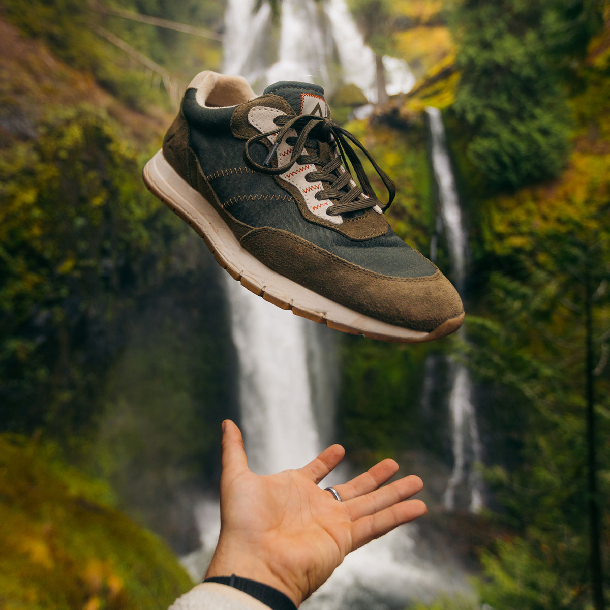 A man tossing the Hasting Sneakers in Khaki Green. Shop Hasting.