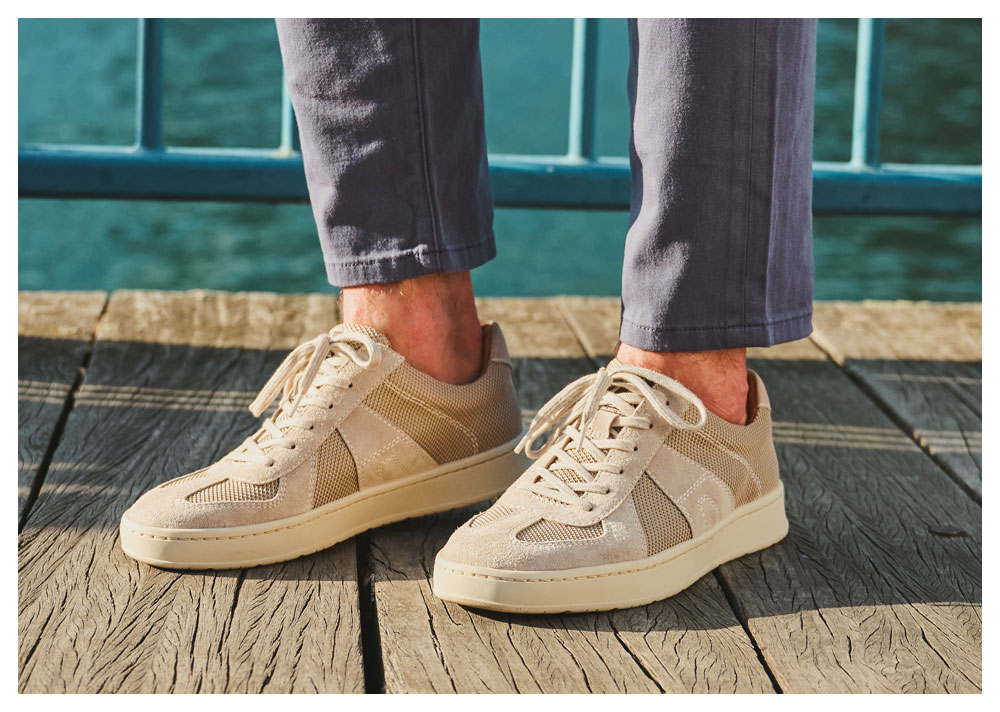 A man wearing the Verano in tan suede and fabric, on a wood boardwalk.