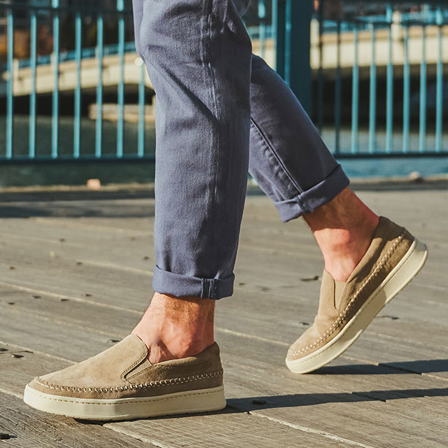 A man wearing the Ventura Slip On Sneakers in light grey. Shop Ventura.