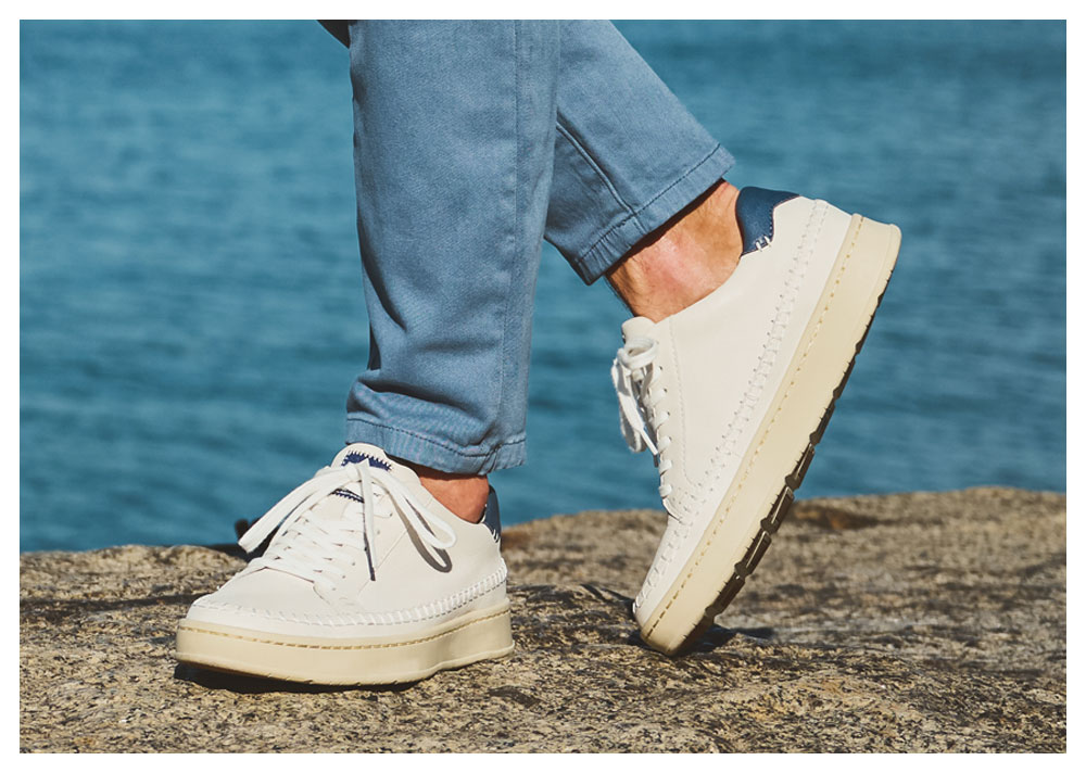 Un hombre que lleva la zapatilla Voyage en color blanco.